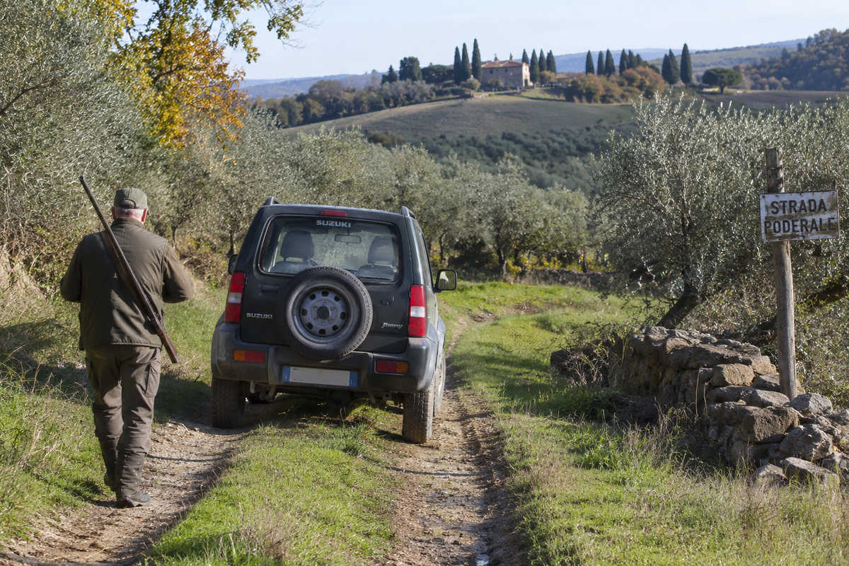 caccia-auto-terreno-agricolo-toscana Automobile su strada poderale in un terreno agricolo durante la stagione venatoria