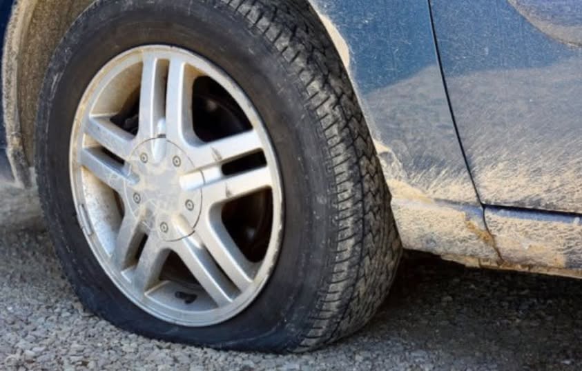 Pneumatico di un’auto sgonfio, immagine utilizzata per raccontare gli episodi di gomme bucate ai cercatori di funghi