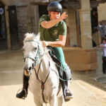 Giostratore in verde su cavallo bianco durante una prova