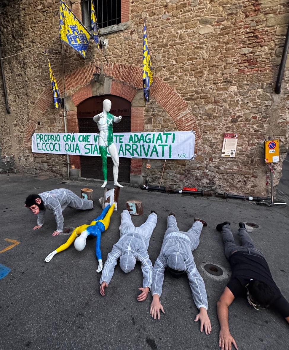 Figuranti sdraiati davanti alla sede di Porta Santo Spirito nella scenetta di sfottò attribuita a Porta Sant'Andrea dopo la Giostra 2026