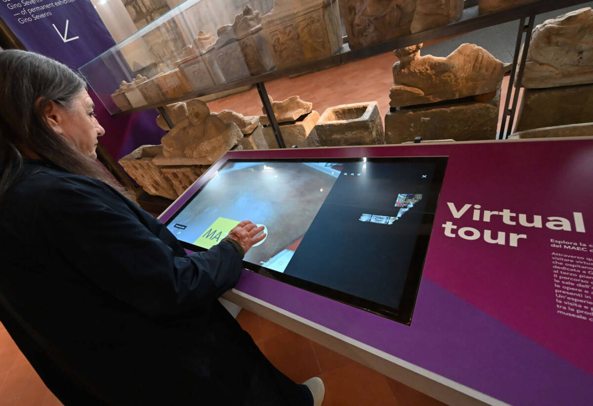 Visitatore consulta un dispositivo multimediale della mostra Severini